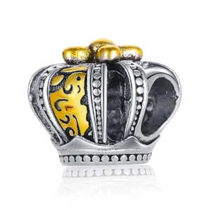 Detail of silver and gold crown charm with hollow patterns and embossed dots