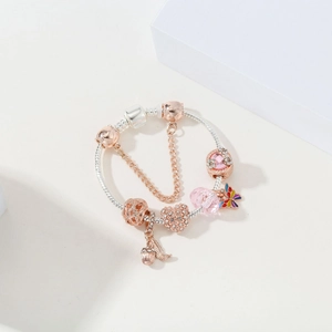 Detailed shot of two-tone silver and rose gold charm bracelet with pavé heart and butterfly