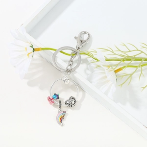 Macro shot of silver keychain with rainbow, globe, and Bee Happy engraved heart charms