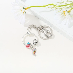 Detail of silver keychain with rainbow, honeycomb, and enamel charms on a white daisy base