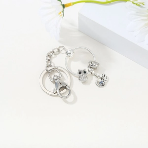 Silver keychain featuring owl and celestial moon star pendants on a snake chain ring