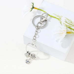 Detail of silver owl charm and blue pendant on a snake chain DIY keychain holder
