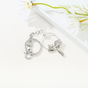 Detail of silver keychain with crown girl, pumpkin carriage and high heel shoe charms