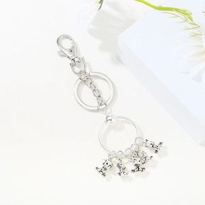 Macro shot of silver metal keychain featuring five cartoon dalmatian puppy pendants