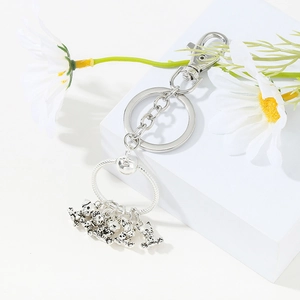 Macro view of silver lobster clasp and animal charms on a circular snake chain keychain