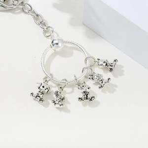 Macro detail of silver keychain with five vintage-style cartoon animal pendants