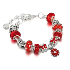 Detail of red crystal beads and silver charms on the festive adjustable charm bracelet