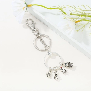 Exquisite silver keychain with four cute cat charms and pink enamel details on a ring