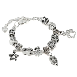 Detailed view of silver charm bracelet with Christmas charms and heart pendants