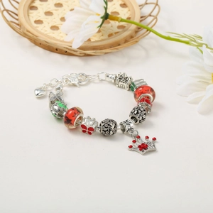 Detail of Christmas beaded bracelet with red glass beads and heart charm on white background