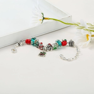 Detail of Christmas themed charm bracelet featuring Santa and tree charms with glowing beads