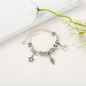 Macro detail of retro silver snake chain bracelet with owl charms and heart beads