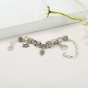 Detailed shot of silver charm bracelet with I Love You heart and owl pendants