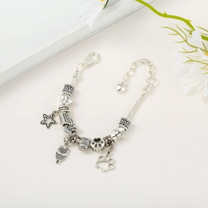 Detailed macro view of vintage silver charm bracelet with engraved stars and owl charms