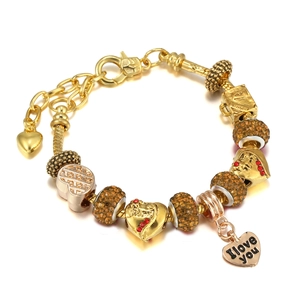 Detail of golden charm bracelet with heart pendant and Paris suitcase charm charms