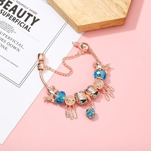 Bracelet attrape-rêves en or rose avec cristaux bleus et breloques éléphant sur rose