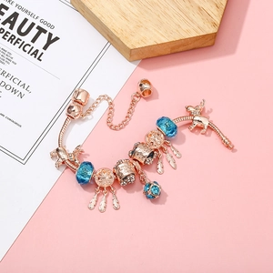 Bracelet maille serpent or rose avec cristaux bleus et charms attrape-rêves sur rose