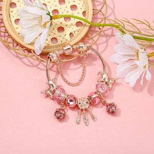 Détail du bracelet rose doré avec pendentif attrape-rêves et perles de cristal rose