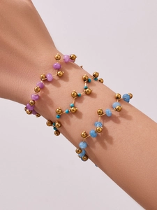 Detailed shot of three gold beaded bracelets with purple, turquoise and blue natural stones