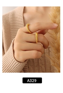 Detail of gold croissant dome rings worn by model, showing ribbed texture and glossy finish
