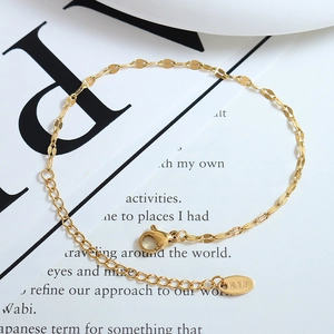 Elegantes K18 vergoldetes Pailletten-Gliederkettenarmband für Damen auf Buchhintergrund