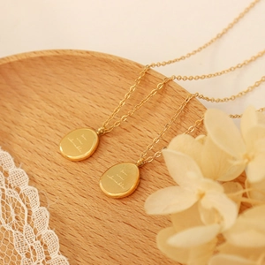 Collier perlé doré avec pendentif ovale gravé You are adorable sur socle en bois