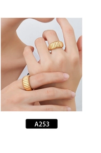 Detail van een gouden croissant ring met geribbeld ontwerp gedragen door een model