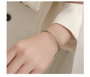 Minimalist silver steel bracelet with thin chain and bead detail on a female wrist