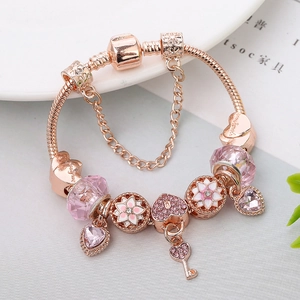 Pulsera de oro rosa con cristales rosas, dijes de flores y colgante de llave de corazón