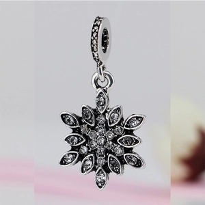 Macro shot of a snowflake charm with vintage silver finish and sparkling pavé zircons