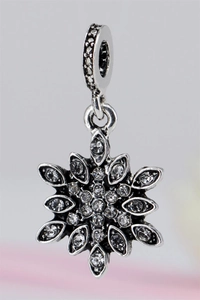 Macro view of a sparkling snowflake charm with pave-set crystals and silver finish