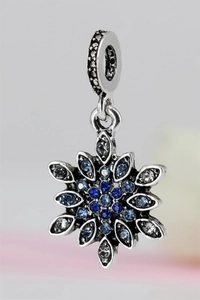 Macro shot of silver snowflake charm with blue crystals and vintage finish for bracelet