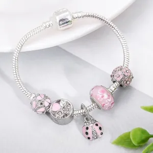 Silver snake chain bracelet with pink glass beads and floral ladybug charms