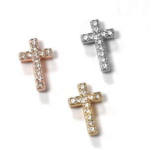 Close-up of cross pendants in gold, silver, and rose gold with pavé-set rhinestones