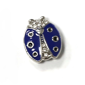 Macro shot of a ladybug pendant with blue enamel wings and clear zircons on the silver body