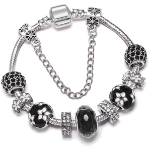 Detailed close-up of a silver snake chain bracelet with black enamel flower beads and zircons