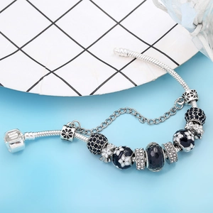 Elegant silver snake chain bracelet with black floral charms and blue rhinestones