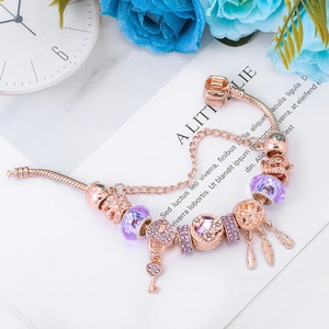 Bracelet maille serpent rose doré avec perles en cristal violet et breloques plumes
