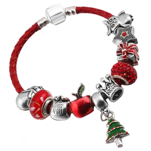 Nahaufnahme eines roten Lederarmbandes mit Weihnachtsbaum- und Kronen-Anhängern