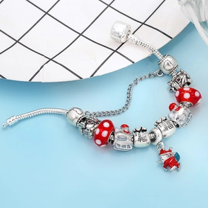 Close-up of DIY charm bracelet with red glass beads and silver cat pendants on snake chain