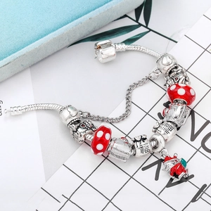 Detail of S925 silver charm bracelet with red glass beads and lucky cat pendants