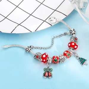 Macro view of Christmas DIY charm bracelet with red beads and festive enamel pendants