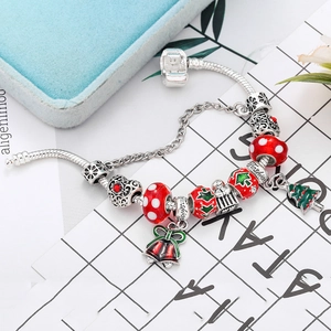Close-up of Christmas charm bracelet with red glass beads and green tree pendant
