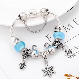 Detailed macro view of snowman charms and blue crystal beads on a silver snake chain