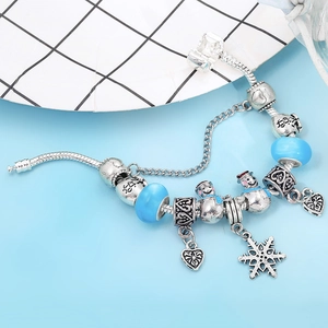 Detail of silver snake chain bracelet with blue beads, snowman and snowflake charms