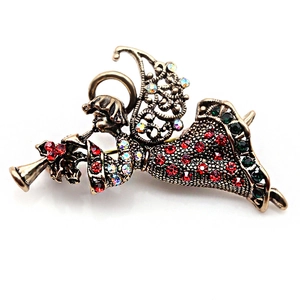 Detailed view of vintage angel brooch with red and green rhinestones and antique gold finish