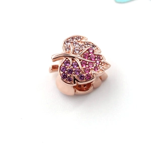 Macro view of rose gold leaf charm with pink gradient pavé zircon crystals