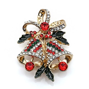 Dettaglio della spilla a campana di Natale con strass rossi e foglie di agrifoglio dorate