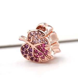 Macro shot of rose gold leaf charm with gradient purple and pink cubic zirconia inlay