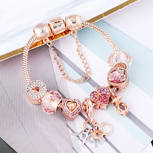 Bracelet à breloques en or rose avec cristaux roses, cœurs et chaîne de sécurité